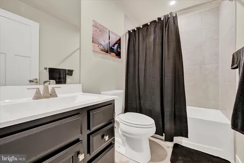a bathroom with a sink a toilet a mirror and shower curtain