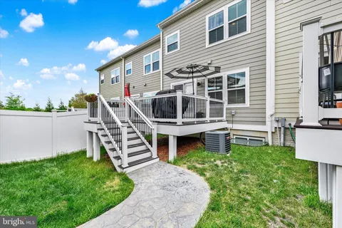a view of a house with backyard and wooden fence