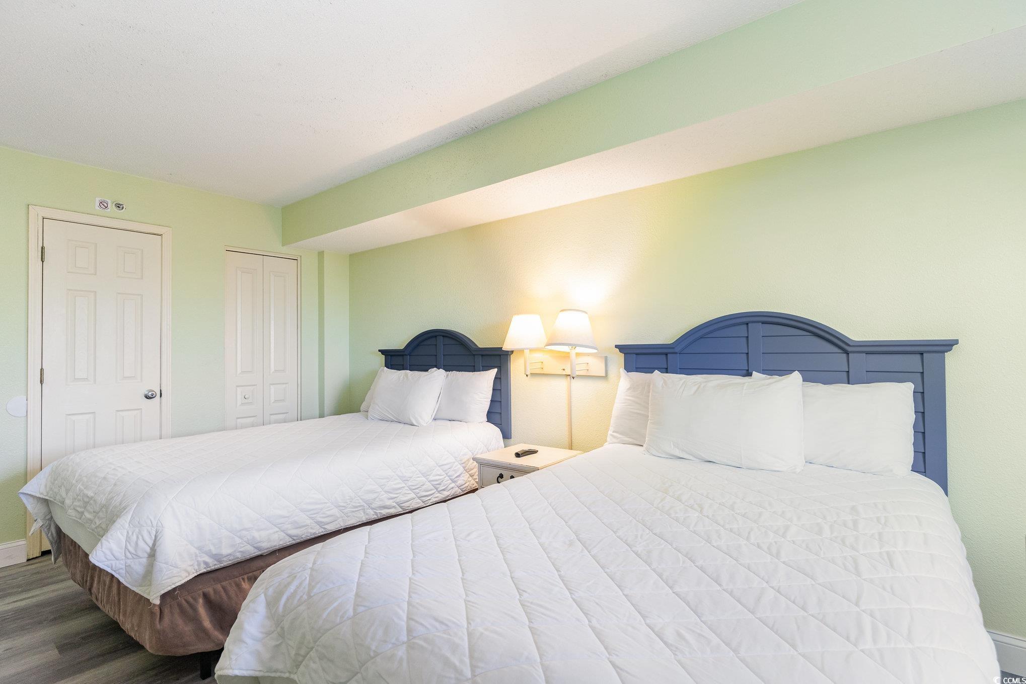7100 North Ocean Boulevard, Unit 320 Myrtle Beach, SC 29572 - Photo 17 of 40 Bedroom featuring wood finished floors, baseboards, and a closet