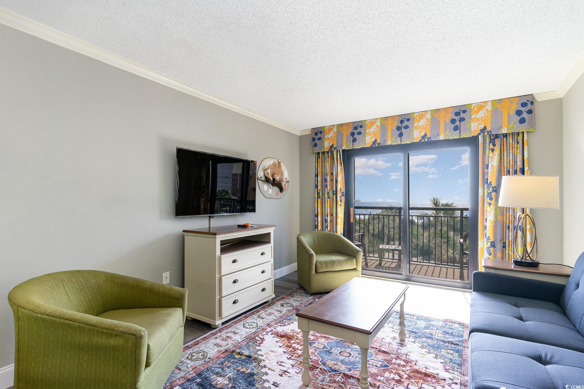 7100 North Ocean Boulevard, Unit 320 Myrtle Beach, SC 29572 - Photo 4 of 40 Living area with crown molding, baseboards, and a textured ceiling