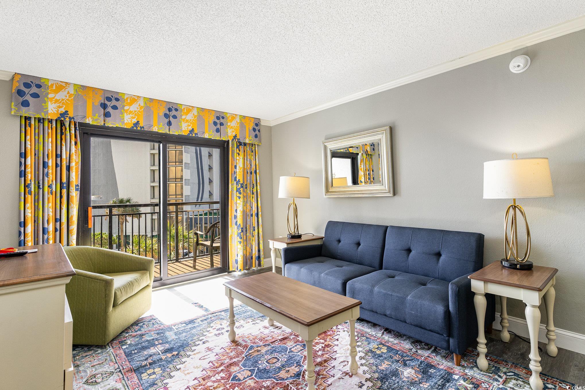 7100 North Ocean Boulevard, Unit 320 Myrtle Beach, SC 29572 - Photo 5 of 40 Living area featuring crown molding, a textured ceiling, and baseboards