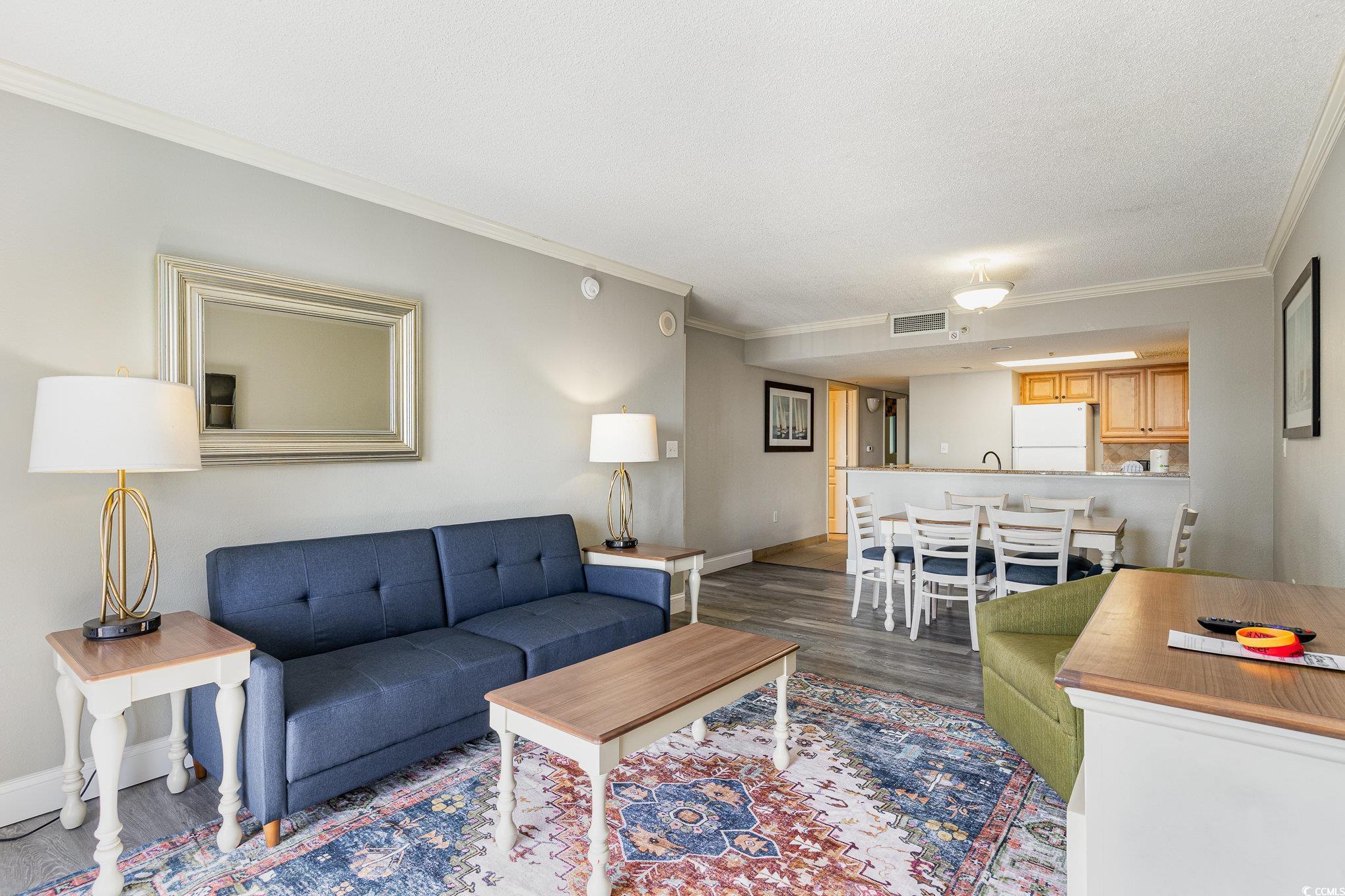 7100 North Ocean Boulevard, Unit 320 Myrtle Beach, SC 29572 - Photo 6 of 40 Living area featuring crown molding, dark wood finished floors, and baseboards