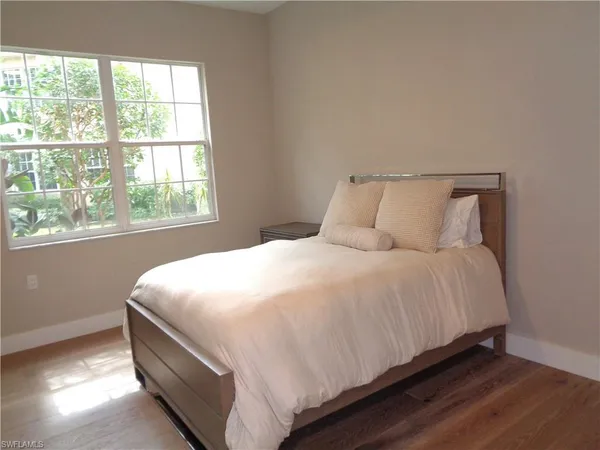 a large bed sitting in a bedroom next to a window