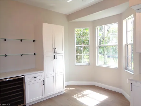 a view of empty room with window and cabinet