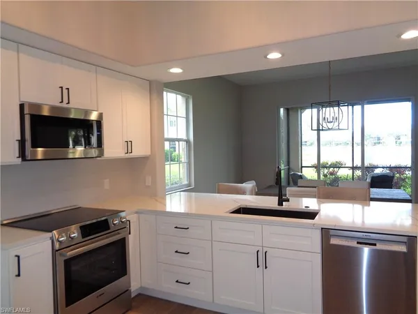 a kitchen with sink a stove and microwave