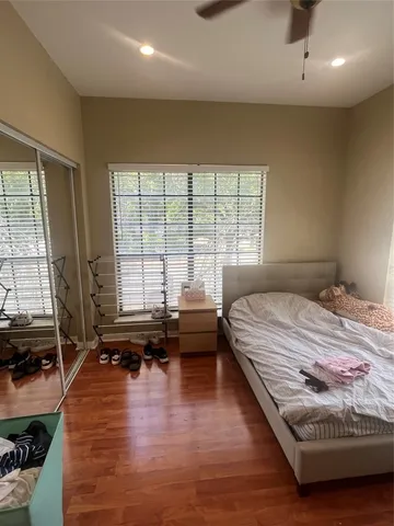 a bedroom with a bed and wooden floor