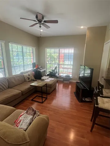 a living room with furniture and a wooden floor