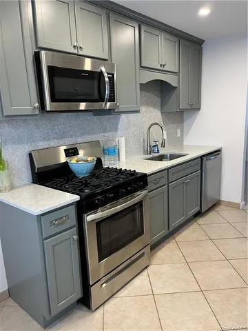 a kitchen with stainless steel appliances granite countertop a stove microwave and sink