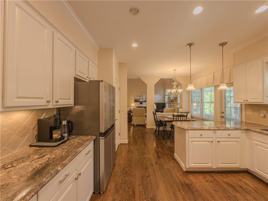 4284 Cedar Bluff Way Southwest Lilburn, GA 30047 - Photo 29 of 62 a kitchen with stainless steel appliances a refrigerator a stove a sink dishwasher and white cabinets with wooden floor