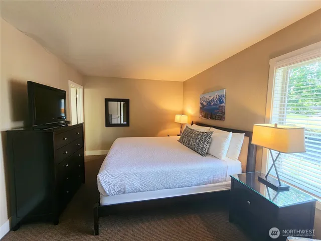 a bedroom with two beds and painting on the wall