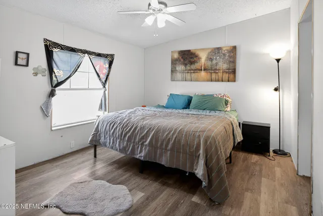 a bedroom with a bed and a painting on the wall