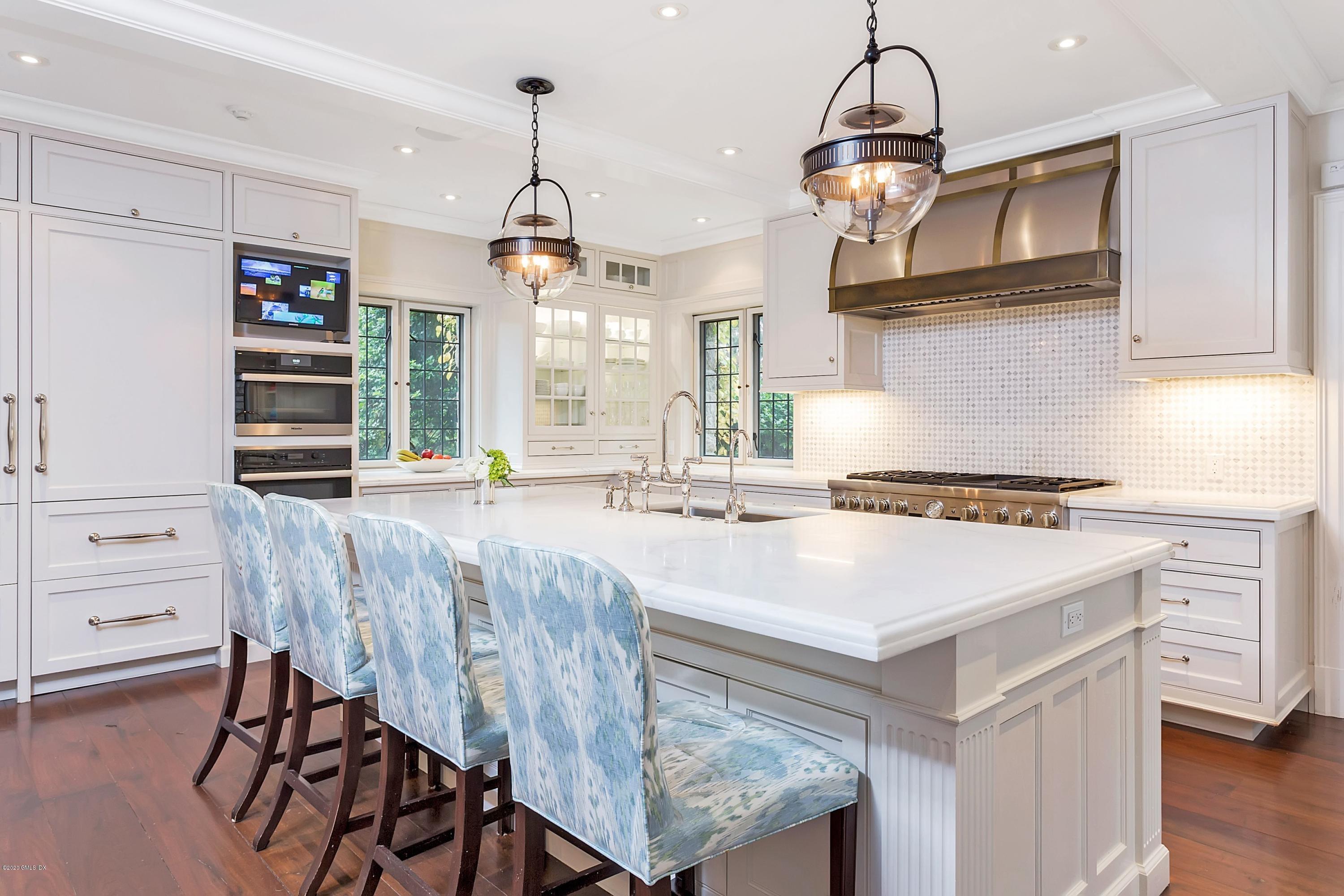 2 Broad Road Greenwich, CT 06830 - Photo 13 of 39 a kitchen with kitchen island a stove a table and chairs in it