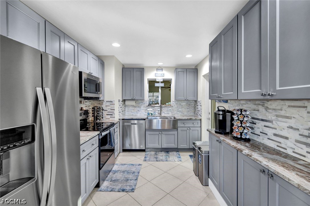 4830 Coquina Road Fort Myers Beach, FL 33931 - Photo 11 of 30 a kitchen with refrigerator and cabinets