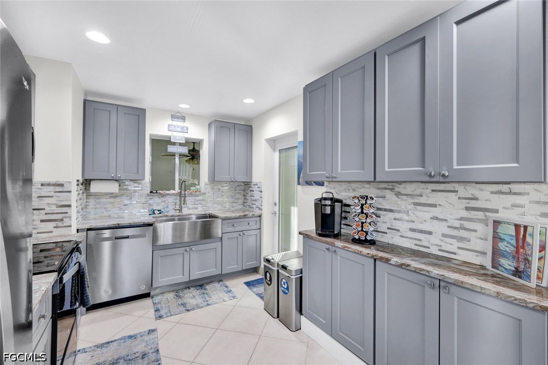 4830 Coquina Road Fort Myers Beach, FL 33931 - Photo 12 of 30 a kitchen with stainless steel appliances granite countertop a sink and cabinets