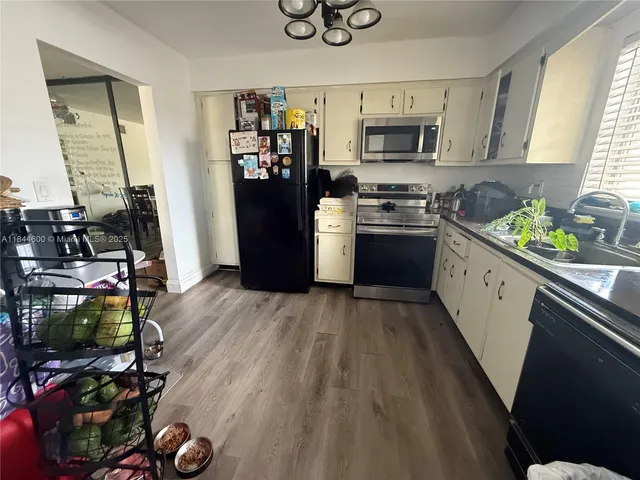 a kitchen with stainless steel appliances a stove top oven a sink and a refrigerator