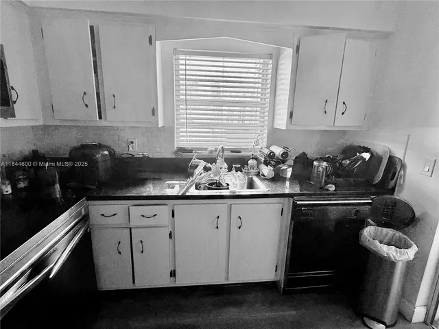 a kitchen with granite countertop white cabinets white appliances a sink and dishwasher