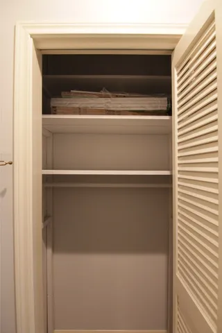 a view of an empty room with wooden floor and closet