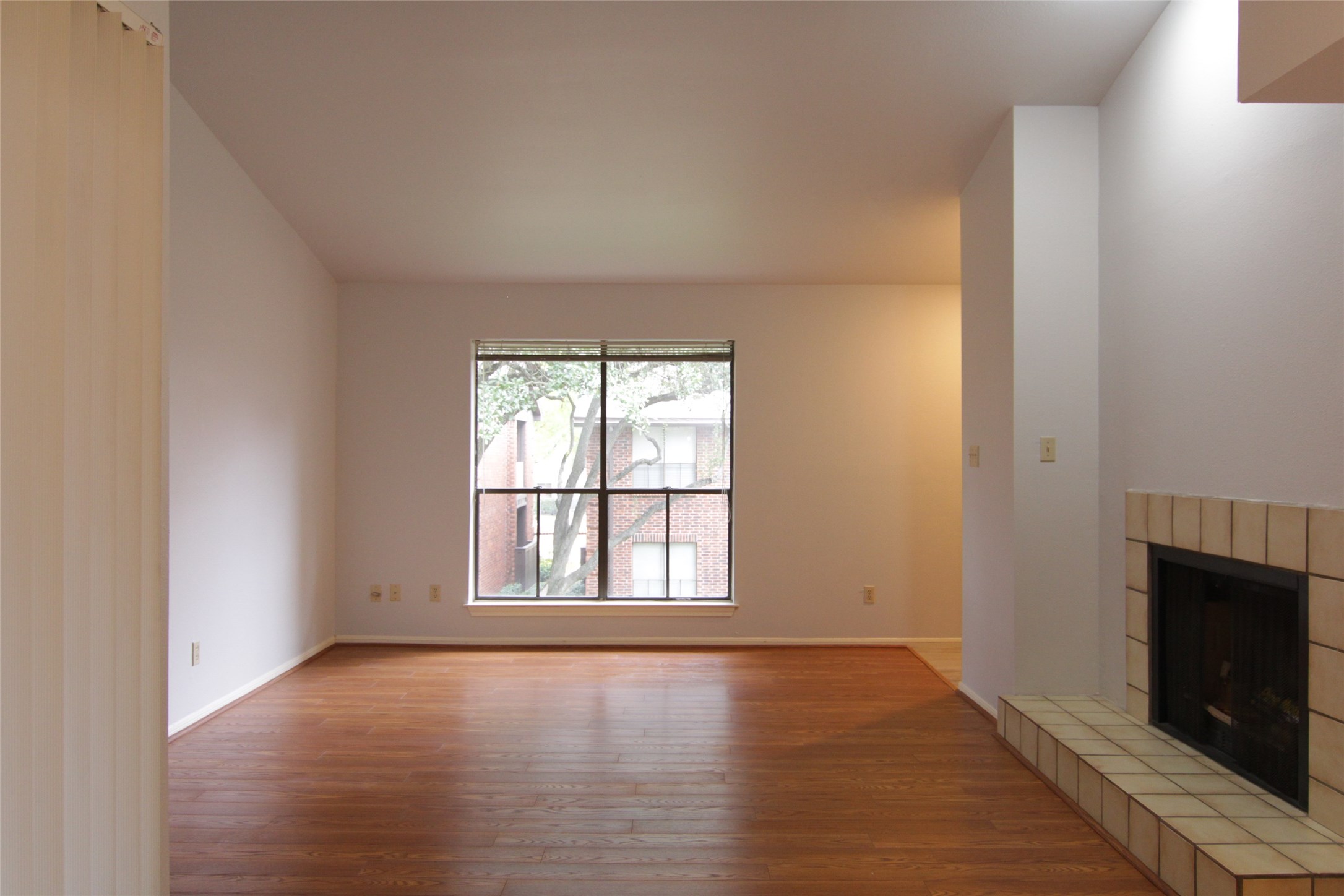 3100 Walnut Bend Lane, Unit 118 Houston, TX 77042 - Photo 6 of 20 an empty room with wooden floor and fireplace