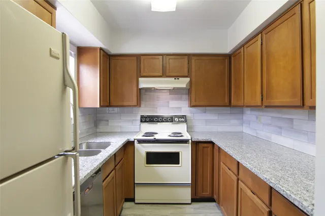 a kitchen with a granite countertop cabinets and refrigerator