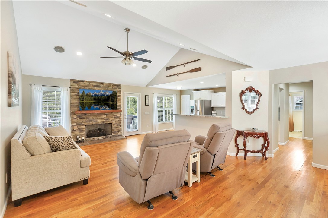 131 Morgan Road West Union, SC 29696 - Photo 3 of 39 A well-lit great room features a stone-faced fireplace, hardwood flooring, and vaulted ceilings.