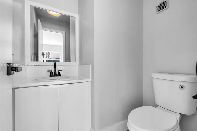 a bathroom with a toilet a sink a vanity and mirror