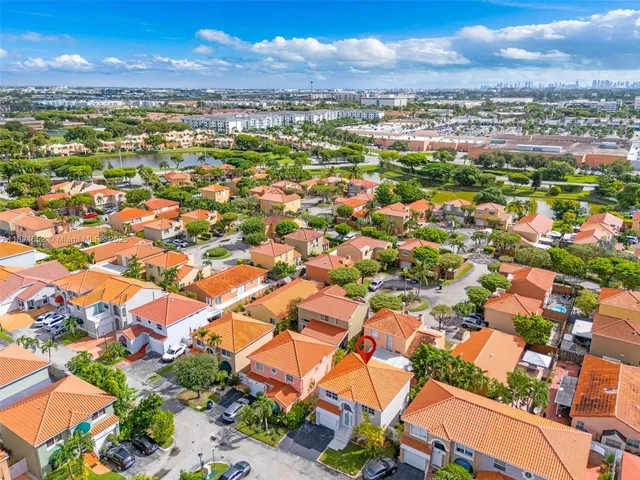 an aerial view of residential houses with outdoor space and ocean view