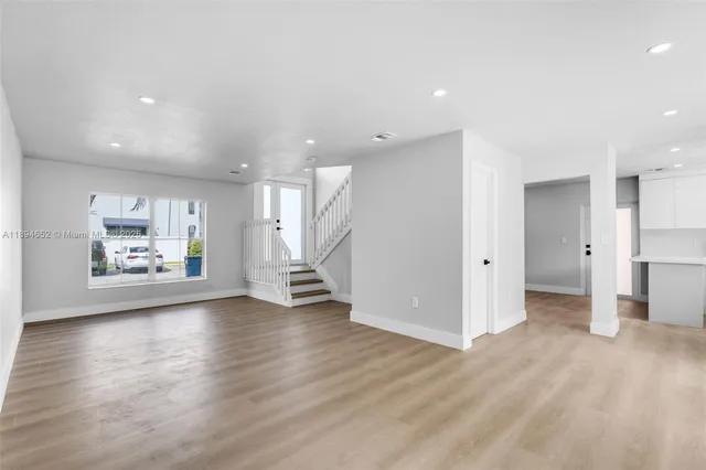 a view of empty room with wooden floor and window