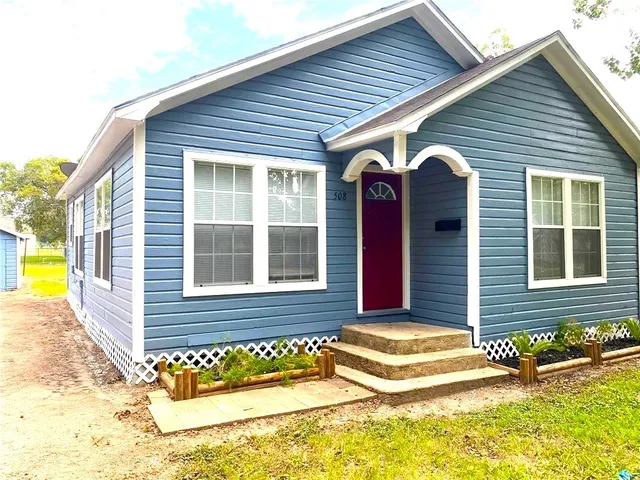 a view of a house with a backyard
