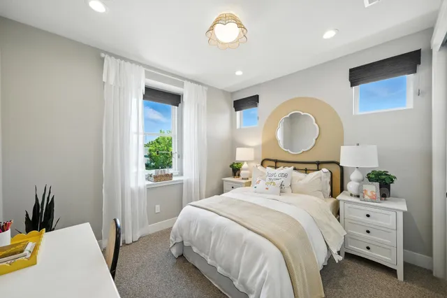 a bedroom with a bed mirror and window