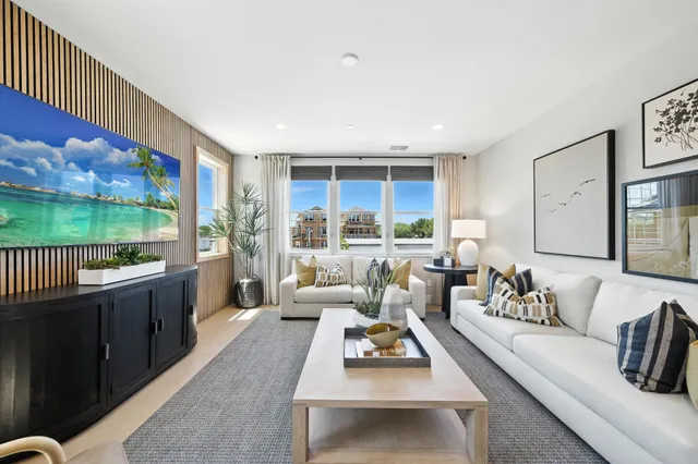 a living room with furniture flat screen tv and a large window