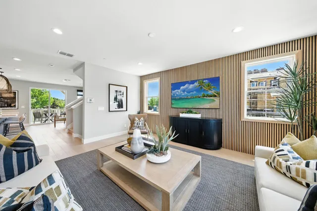 a living room with furniture a flat screen tv and a table