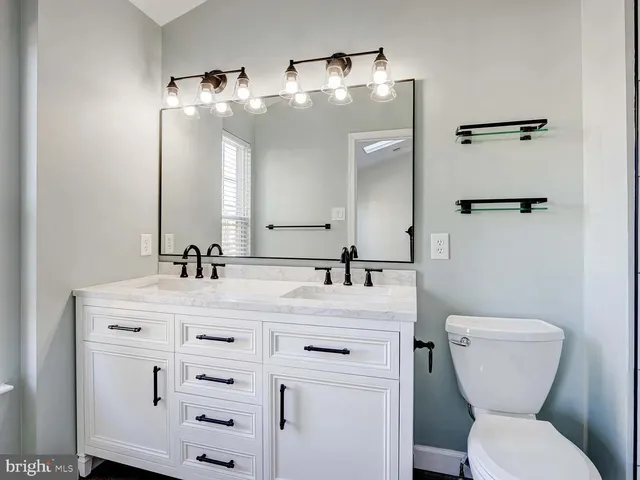 a bathroom with a toilet a sink and mirror