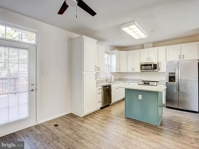 a kitchen with granite countertop a refrigerator stove top oven and sink