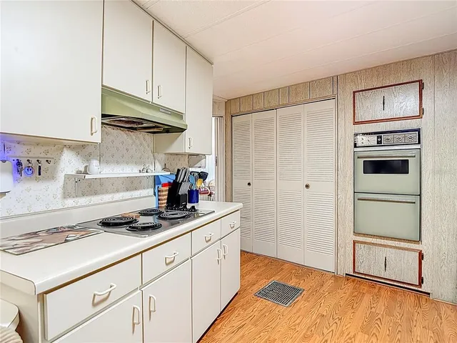 a living room with stainless steel appliances granite countertop furniture wooden floor and a window