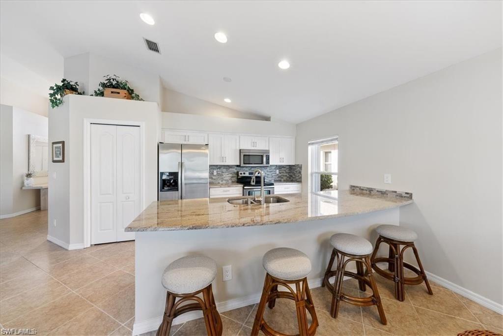 8432 Indian Wells Way Naples, FL 34113 - Photo 13 of 27 a dining hall with stainless steel appliances granite countertop a dining table and chairs