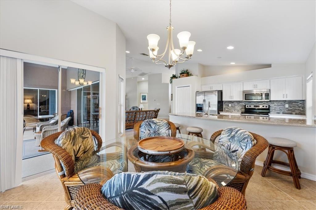 8432 Indian Wells Way Naples, FL 34113 - Photo 14 of 27 a view of a dining room with furniture and wooden floor