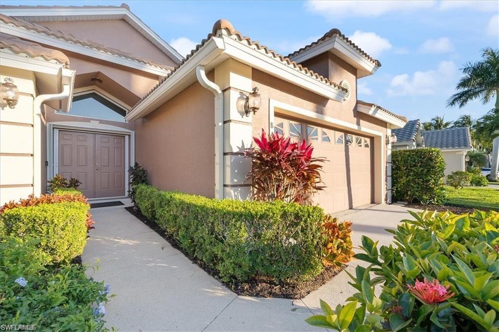 8432 Indian Wells Way Naples, FL 34113 - Photo 24 of 27 a front view of a house with a yard
