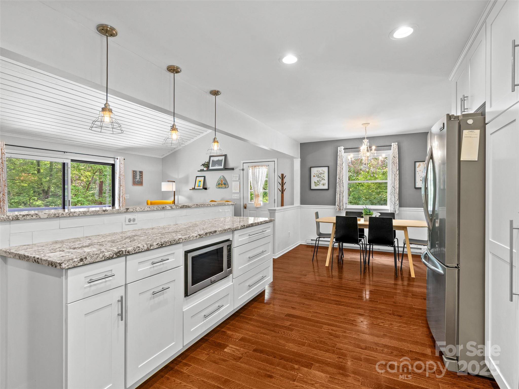 220 Deer Run Road Canton, NC 28716 - Photo 14 of 46 a kitchen with stainless steel appliances granite countertop a stove oven a dining table and chairs with wooden floor