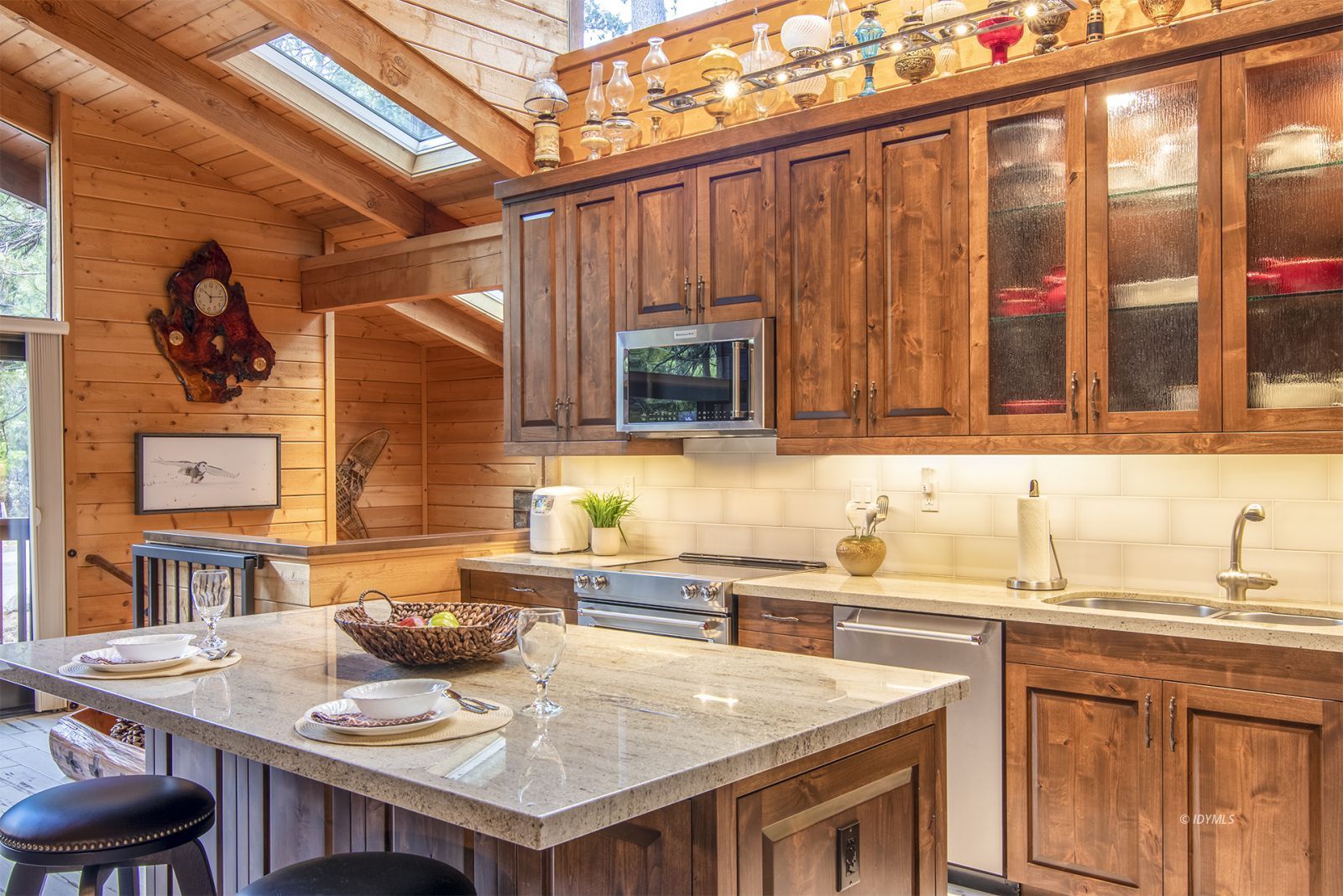 24924 Fern Valley Road Idyllwild, CA 92549 - Photo 15 of 44 a kitchen with a sink a stove and chairs