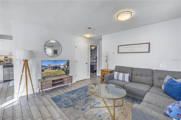 a living room with furniture and a wooden floor