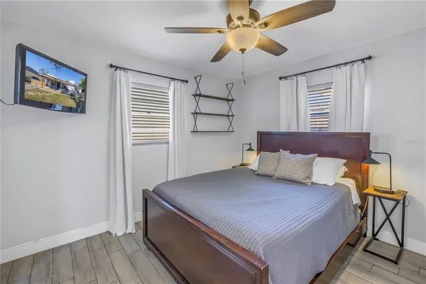 a bedroom with a large bed a chandelier and a window