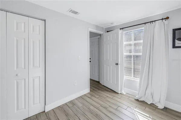 a view of empty room with wooden floor