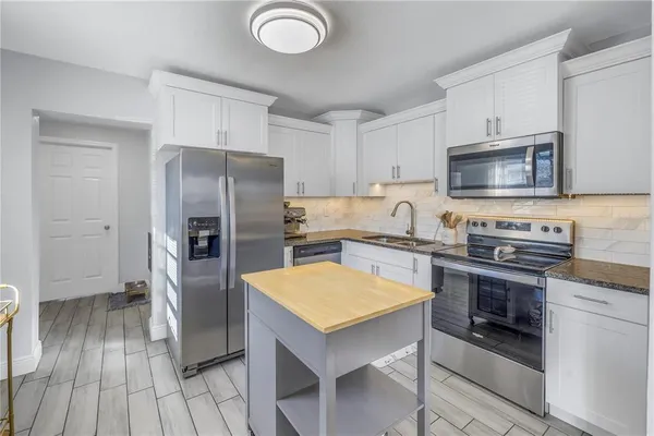 a kitchen with a refrigerator sink and stove top oven