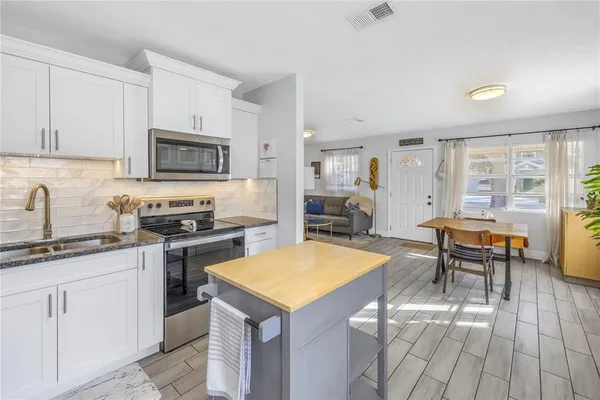 a kitchen with sink cabinets and dining table