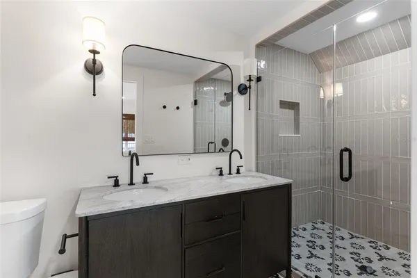 a bathroom with a double vanity sink mirror and shower