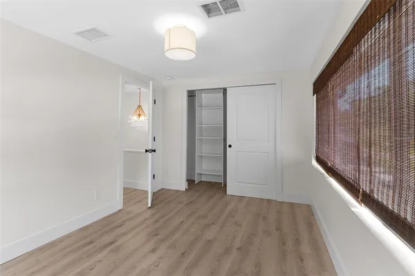 a view of an empty room with wooden floor