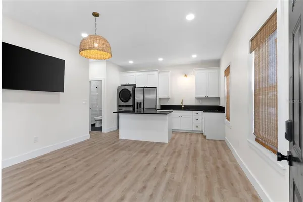 a view of kitchen with stainless steel appliances kitchen island wooden floor and window
