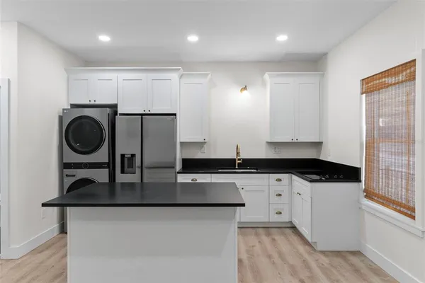 a kitchen with granite countertop a sink a stove and cabinets