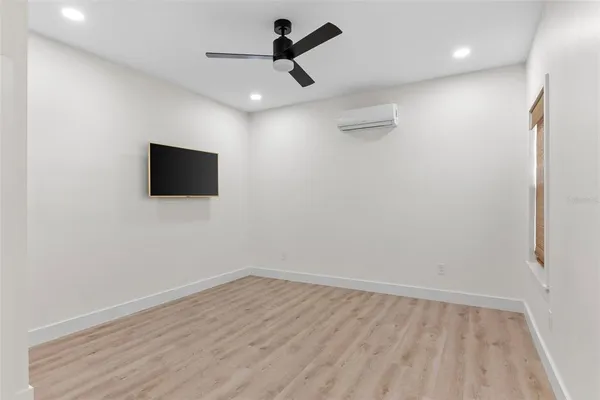 a view of a livingroom with wooden floor and a ceiling fan