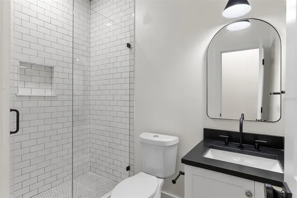 a bathroom with a sink a toilet and mirror